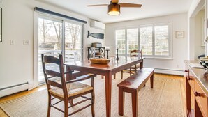 A dining area with a wooden table, chairs, and a ceiling fan. - 1 Mi to Sand! Mid-Cape Chatham w/ Furnished Deck (Chatham)