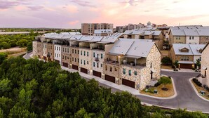 Un quartier résidentiel composé d’immeubles à plusieurs étages, d’une route sinueuse et entouré de verdure.