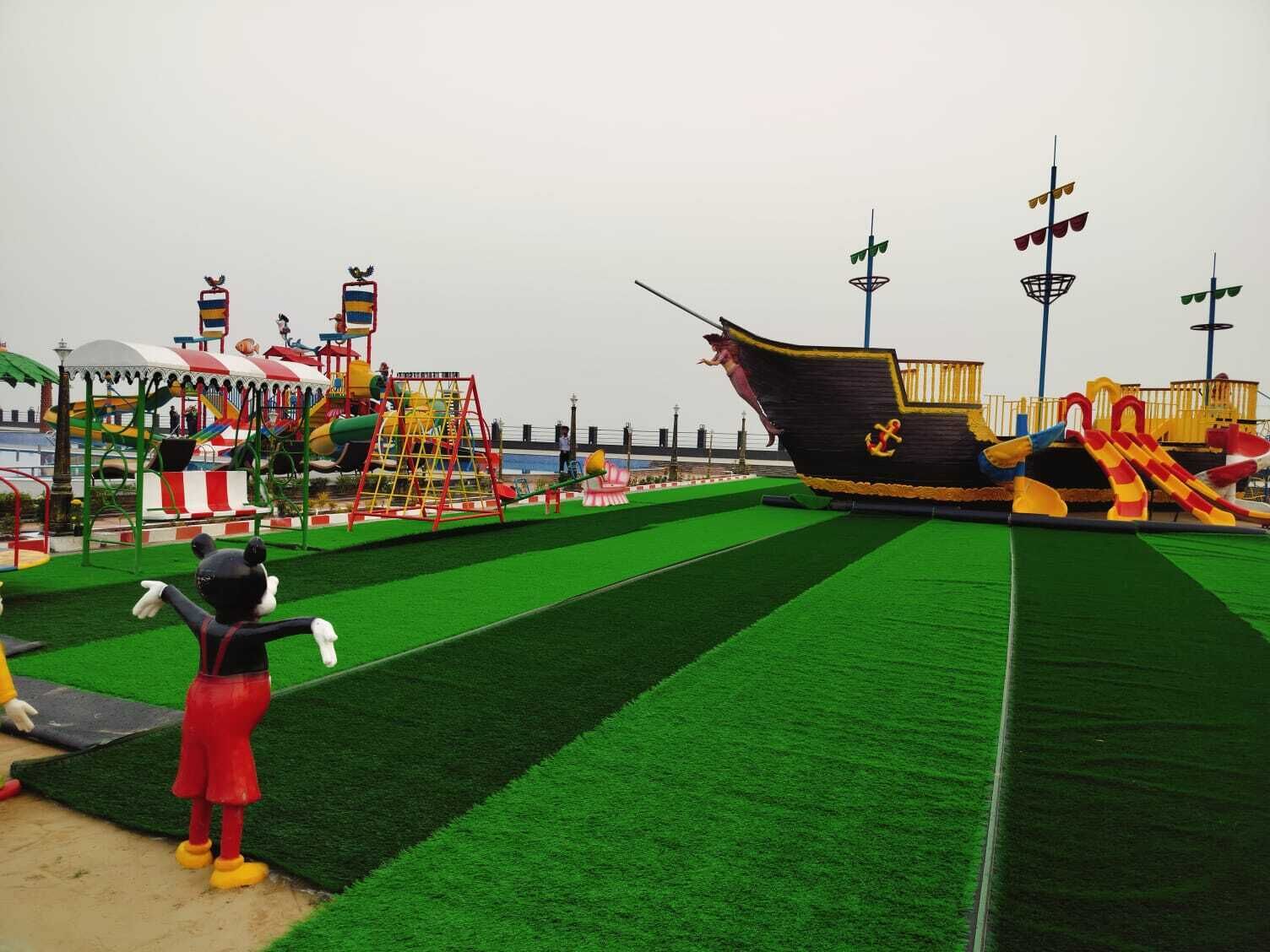 A playground with artificial grass, a pirate ship, and various play structures.