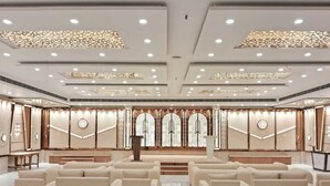 A spacious, elegantly designed hotel lobby with a central seating area, decorative wall panels, and a large, ornate chandelier. - Prime beach resort  Mandarmani (Kanthi)