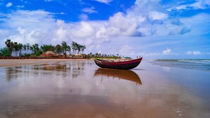 A boat on a beach with a clear sky and palm trees in the background. - Prime beach resort  Mandarmani (Kanthi)