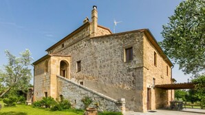 A stone building with a sloped roof, a chimney, and a small balcony. - Il Piccione by Interhome (Pitigliano)