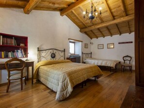 A bedroom with a wooden ceiling, a bed, a chair, a desk, and a bookshelf. - I 3 Faggi by Interhome (Pistoia)