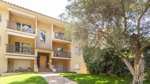 A multi-story building with a balcony on the ground floor, a sign reading "Melis II," and a paved walkway leading to the entrance. - "Melis II M4 Playa de Pals" by Interhome (Pals)