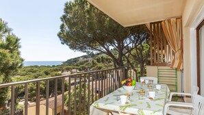 A balcony with a table set for two, overlooking a coastal landscape. - "Melis II M8 Playa de Pals" by Interhome (Pals)