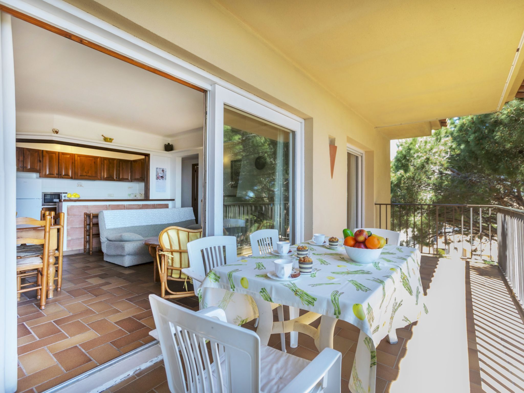 An open-plan living area with a kitchen, dining table, and chairs.