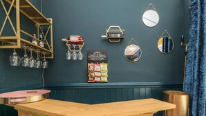 Zona de bar con mostrador de madera, copas de vino y un cartel que dice 'Wine improves with age'.