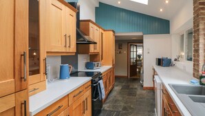 Una cocina moderna con armarios de madera, una estufa y un tostador.