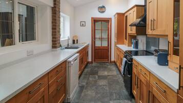 A kitchen with wooden cabinets, a dishwasher, and a stove.