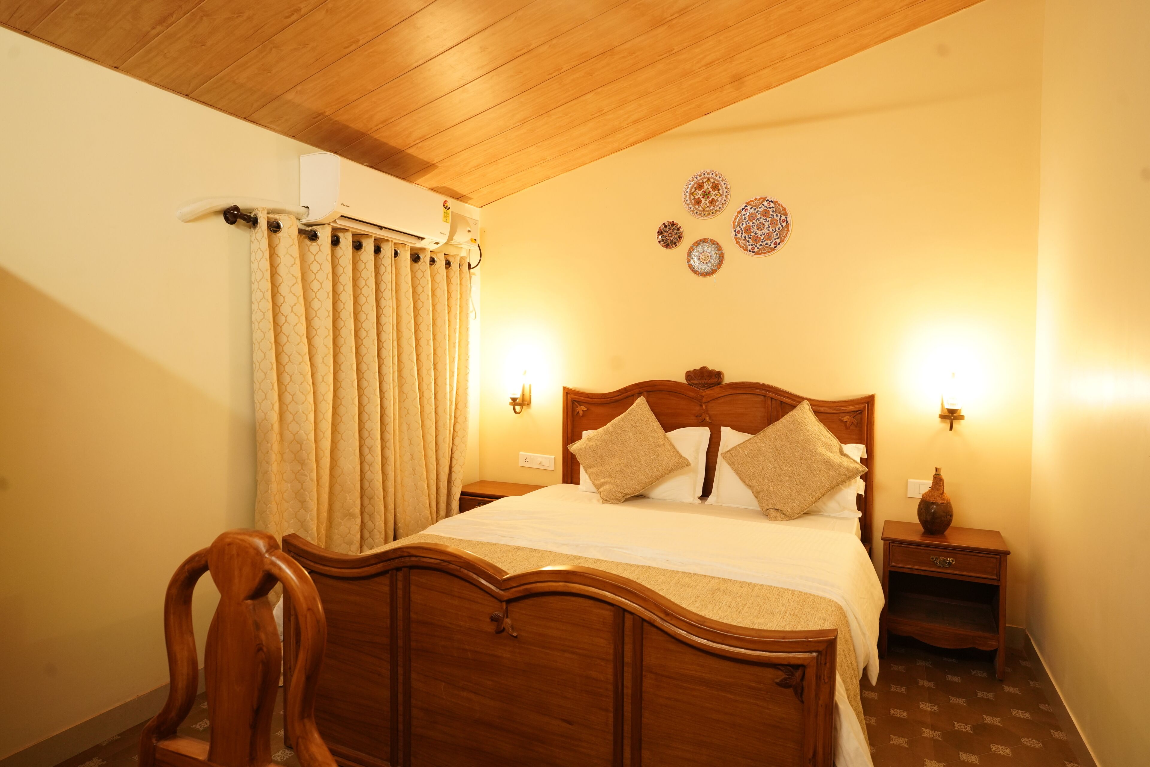 Une chambre à coucher avec un lit en bois, deux tables de chevet, une commode, une chaise et un climatiseur fixé au mur.