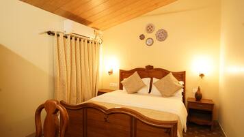 Une chambre à coucher avec un lit en bois, deux tables de chevet, une commode, une chaise et un climatiseur fixé au mur.