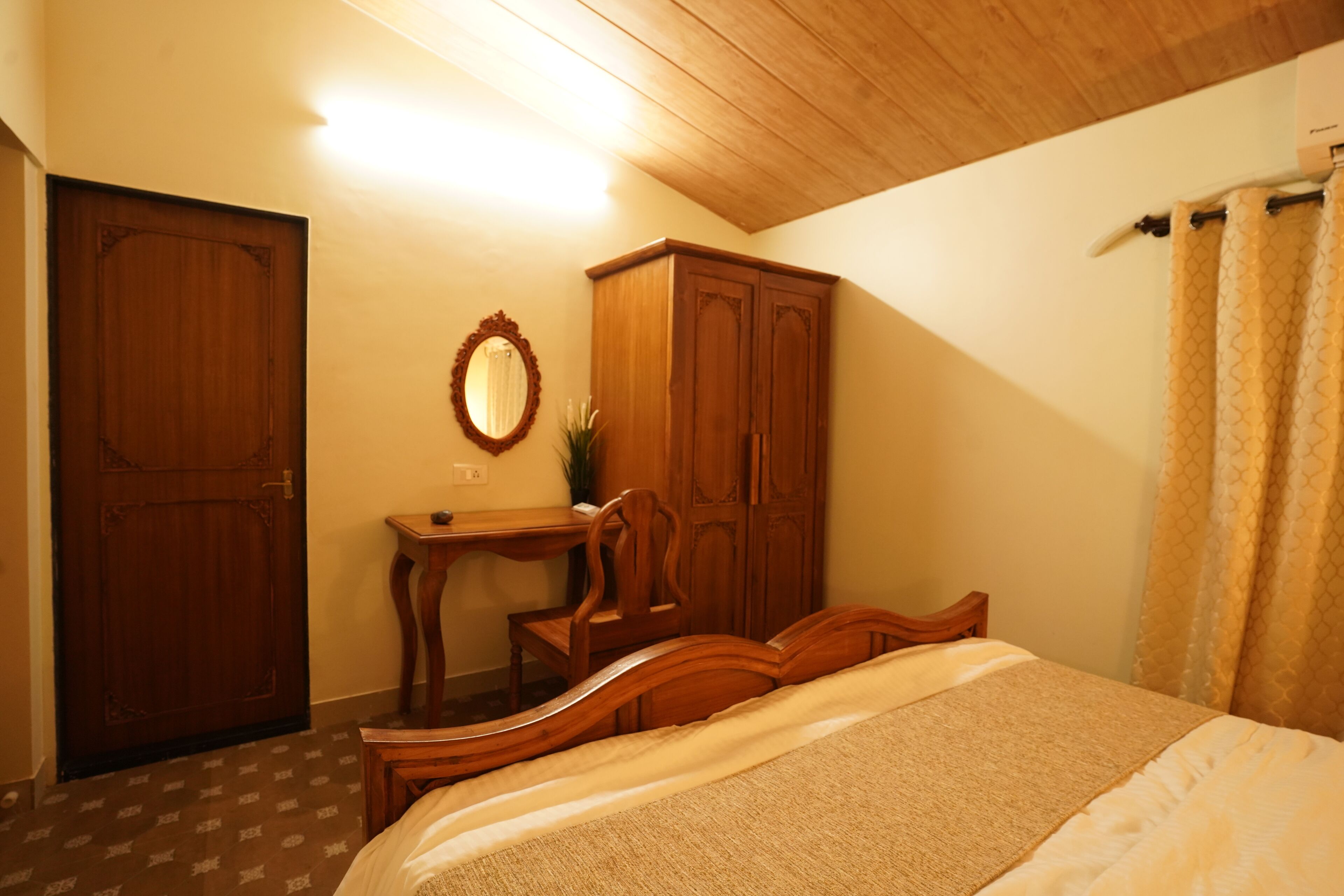 A bedroom with a wooden bed, a desk with a mirror, and a wardrobe.