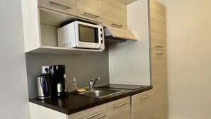 A compact kitchen with a microwave, coffee maker, and sink. - T2 vue Montagne, Accès Direct aux Pistes, Avec Piscine (Vars)