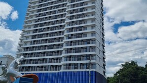 A high-rise building with multiple balconies and a blue facade. - 환상적 전면 오션뷰/일출 성지/죽도 해변/인구 해변/서핑 성지/물놀이 (Yangyang)