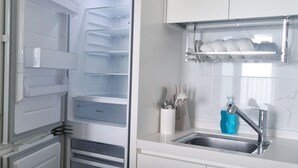 A kitchen with a built-in refrigerator, a sink, and a dish rack. - 환상적 전면 오션뷰/일출 성지/죽도 해변/인구 해변/서핑 성지/물놀이 (Yangyang)