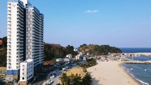A high-rise hotel with multiple floors, a beachside location, and a view of the ocean. - 환상적 전면 오션뷰/일출 성지/죽도 해변/인구 해변/서핑 성지/물놀이 (Yangyang)