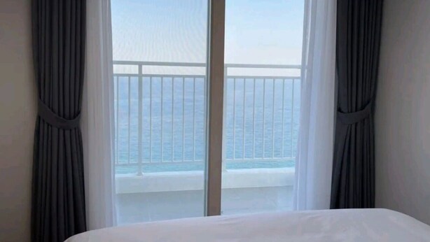 A hotel room with a large window offering a view of the sea. - 환상적 전면 오션뷰/일출 성지/죽도 해변/인구 해변/서핑 성지/물놀이 (Yangyang)