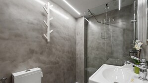Une salle de bain moderne équipée de toilettes, d’un lavabo et d’une douche.