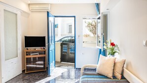 Un salon avec un canapé, un téléviseur et une vue sur l’extérieur.