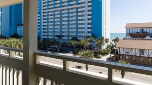 A high-rise hotel with multiple floors, a balcony with railings, and a view of the ocean. - Seaside Serenity: 2BR, 2BA with Resort View (Myrtle Beach)