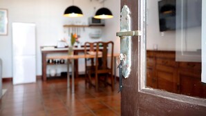 Una cocina con comedor, un armario de madera y una puerta con manija metálica.