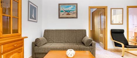A living room with a sofa, a wooden coffee table, a cabinet, and a framed picture on the wall.