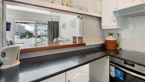 Eine moderne Küche mit schwarzem Arbeitsplatz, weißen Schränken und einem eingebauten Backofen.