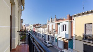 A narrow street with buildings on either side, a balcony with a railing, and parked cars. - Holiday Home "La Matea" with Private Terrace, Balcony and Wi-Fi (LLAURÍ)
