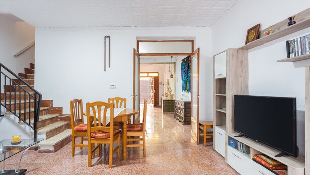 A living room with a dining area, a TV, and a staircase. - Holiday Home "La Matea" with Private Terrace, Balcony and Wi-Fi (LLAURÍ)