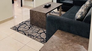 Un soggiorno moderno con un divano, un tavolino da caffè e una zona cucina sullo sfondo.