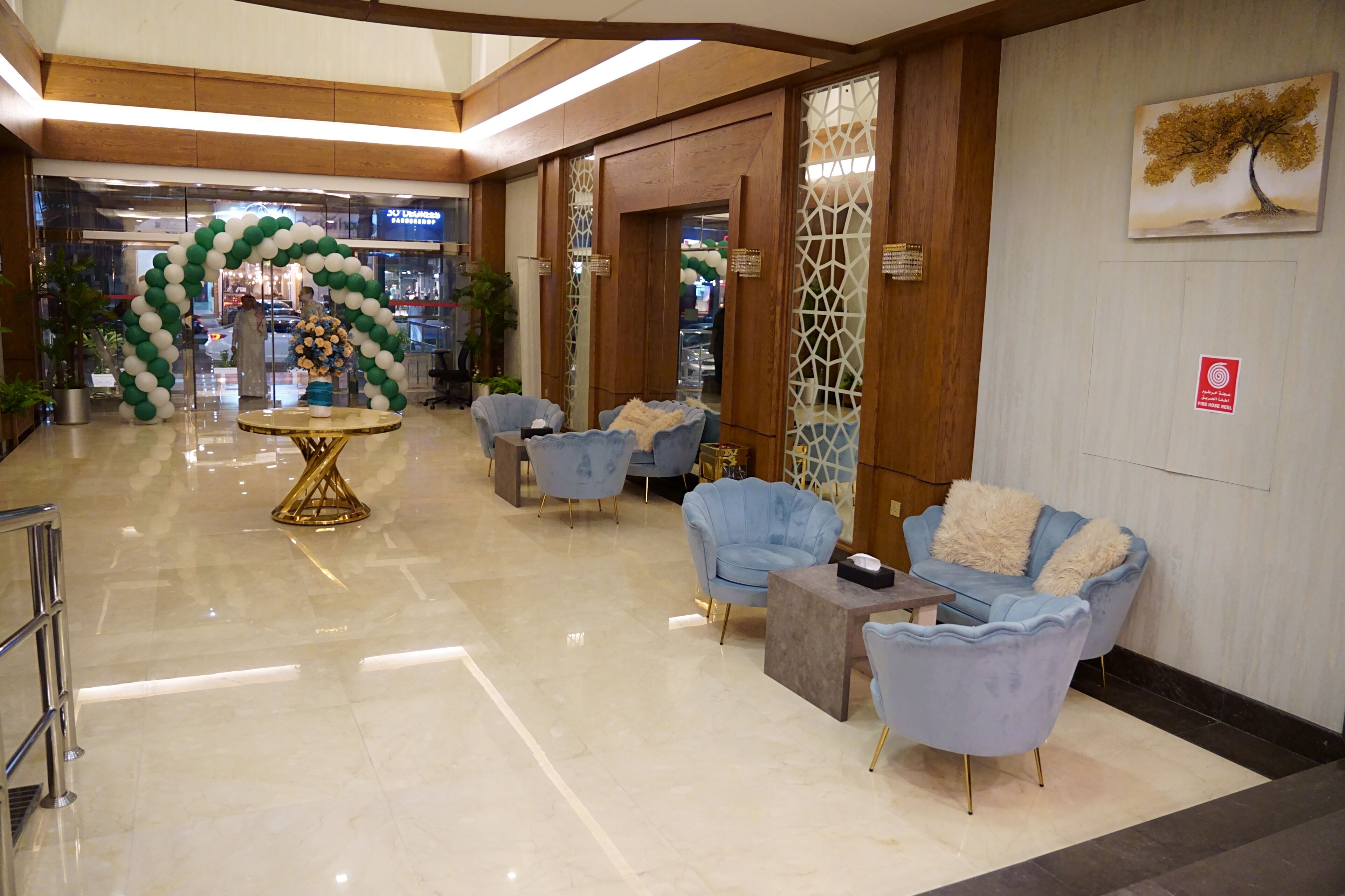 A lobby with a reception area, seating, and a decorative archway.