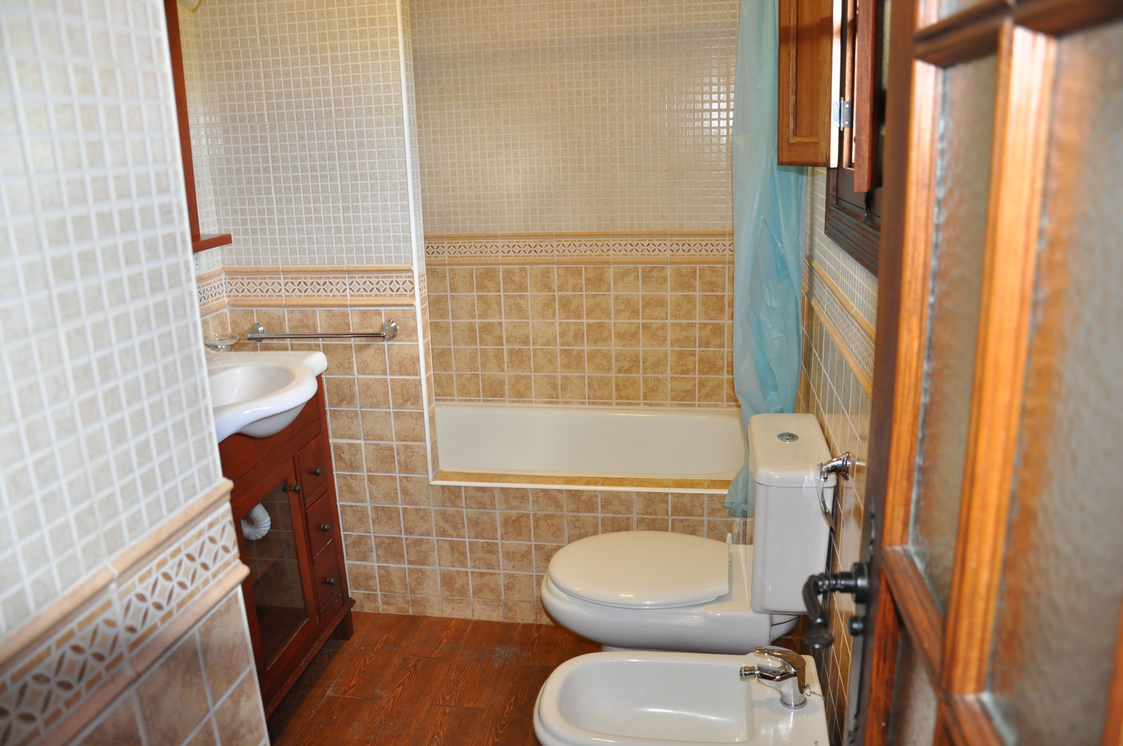 A bathroom with a toilet, bidet, sink, and bathtub.