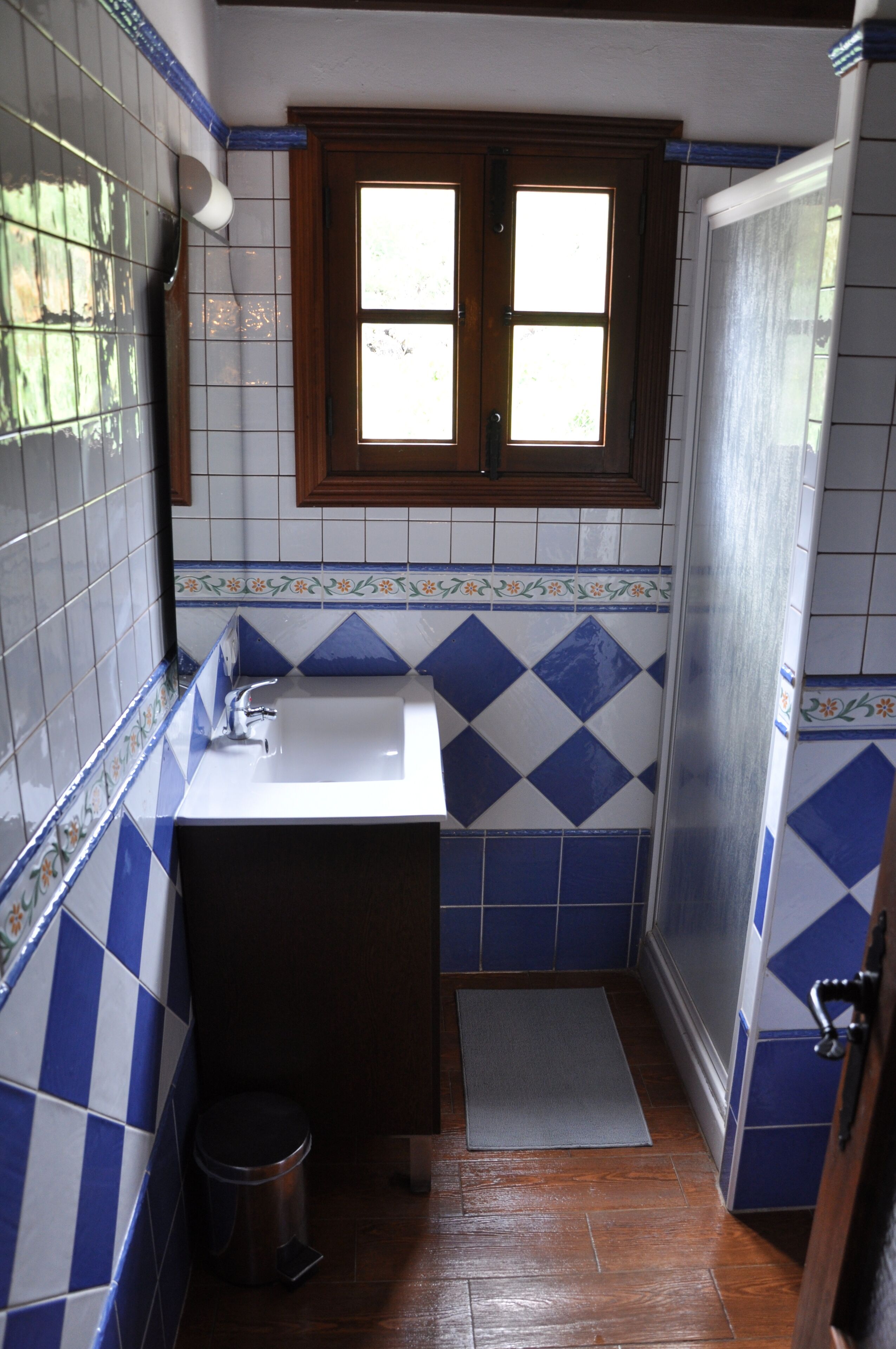 Un baño con lavamanos, ventana y puerta.