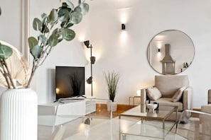 Un salon moderne avec un canapé, une table basse et un grand miroir.