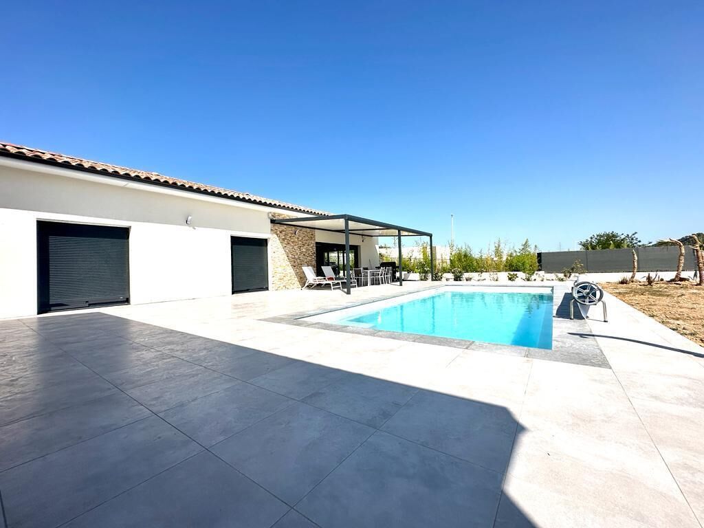 A modern house with a swimming pool, covered patio, and a garage.
