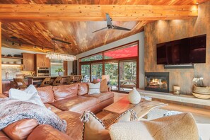 A spacious living room with a leather sofa, wooden coffee table, and a fireplace.