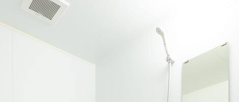 Une salle de bain moderne équipée d’une baignoire, de toilettes, d’une douche et d’un miroir.