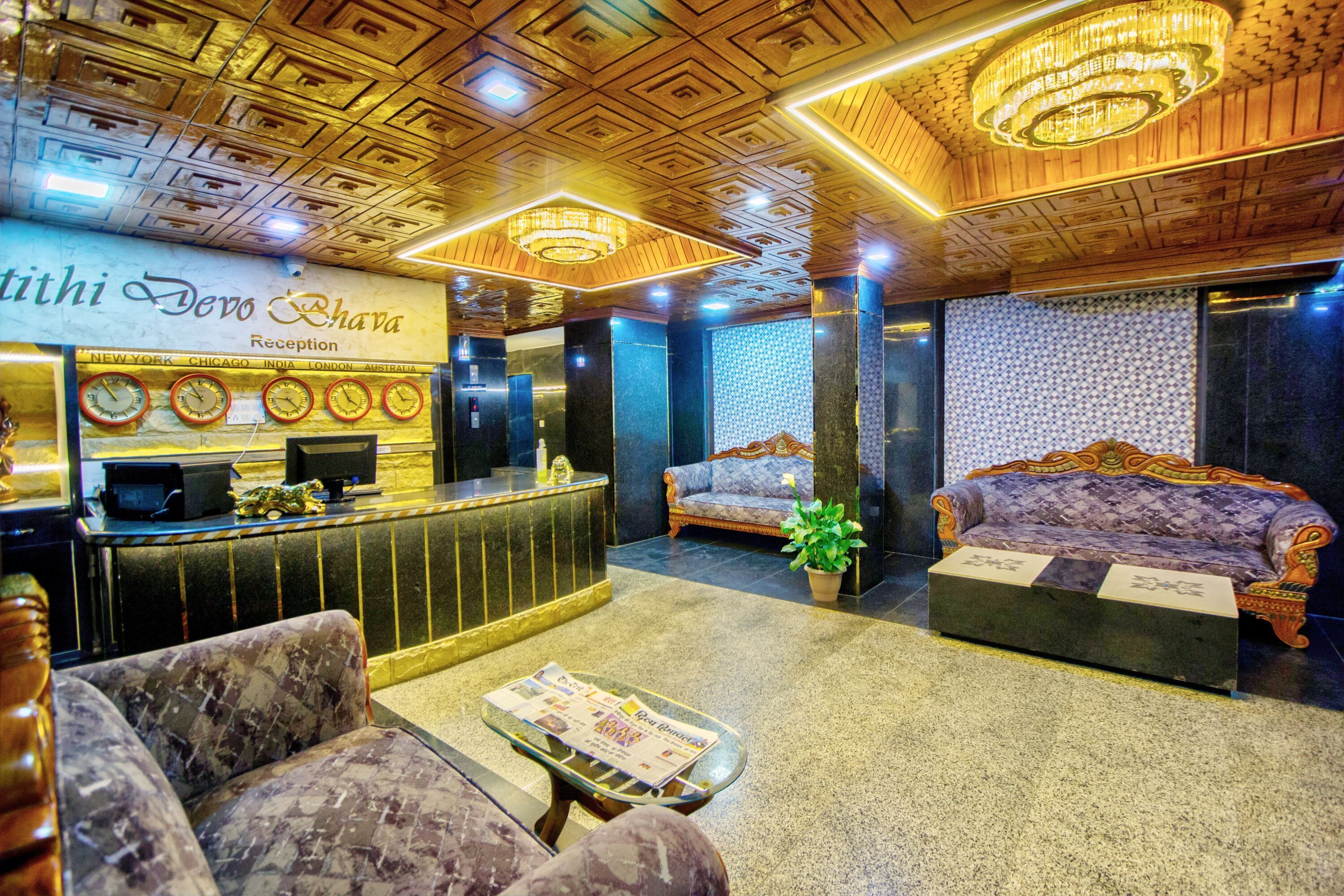 A reception area with a wooden ceiling, a reception desk, two sofas, and a potted plant.