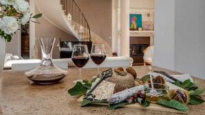 A dining table with a cheese wheel, glasses of red wine, a honey dipper, nuts, and a decorative vase. - Villa with private pool in The Tuscan Countryside (Figline e Incisa Valdarno)
