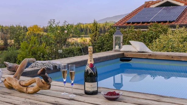 A poolside setting with a bottle of Moët & Chandon champagne, two glasses, a bowl of berries, and a wooden sculpture. - Villa with private pool in The Tuscan Countryside (Figline e Incisa Valdarno)
