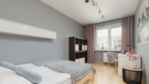 Une chambre à coucher moderne avec un lit, un bureau et une chaise.