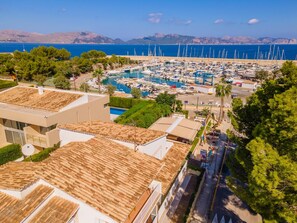 Marina con barcos, piscina y edificios de techos de teja.