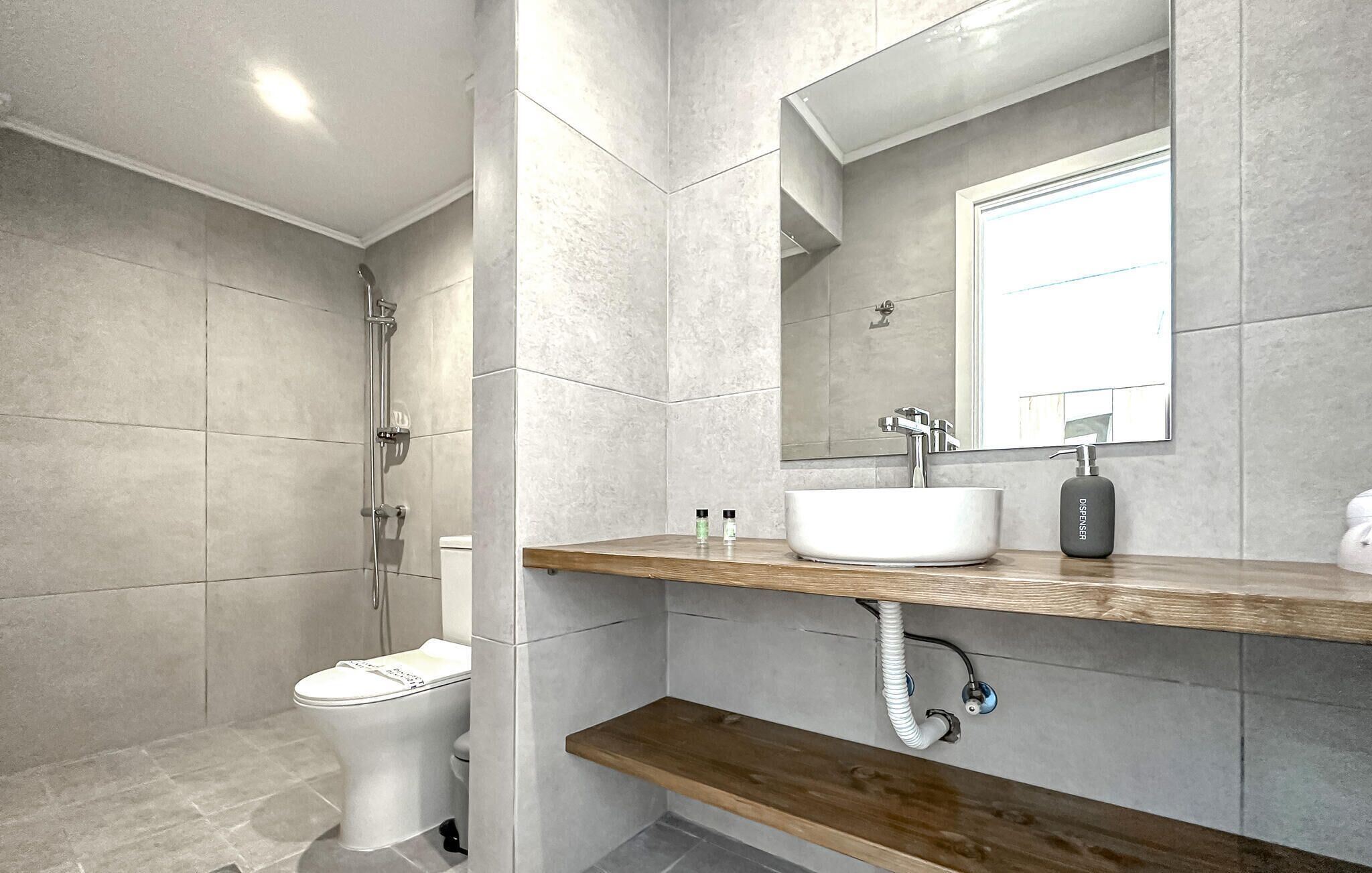 Un baño moderno con inodoro, ducha y lavamanos.