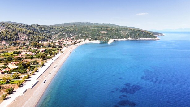 A coastal town with a long beach, clear blue sea, and hilly terrain in the background. - Beach front home in Vasilika Evia (Vasilika Evia)