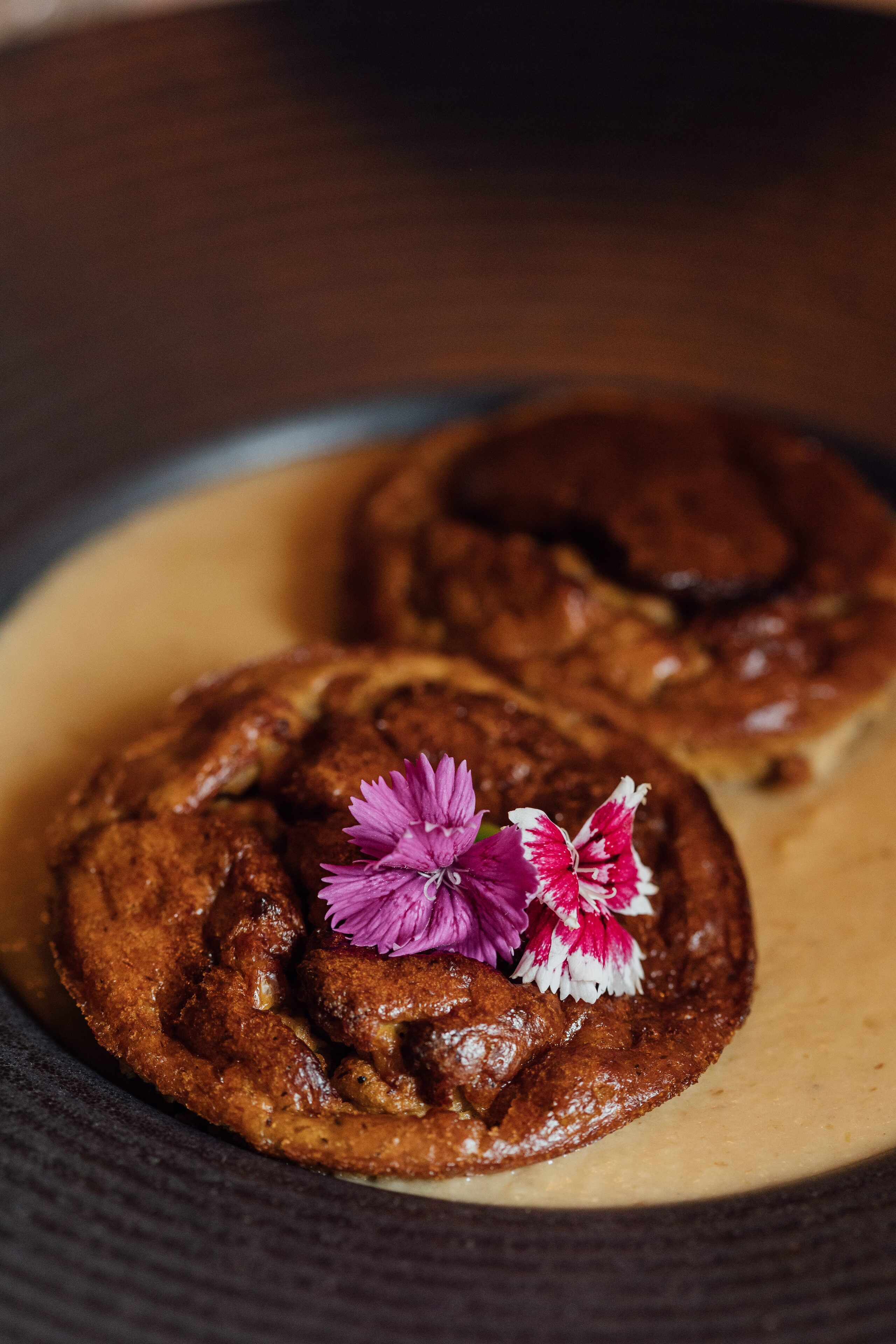 Une assiette à dessert avec deux biscuits au chocolat et une décoration florale.