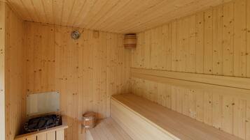 Una sauna de madera con bancos y un asiento de banco, un banco de madera y un taburete de madera pequeño.