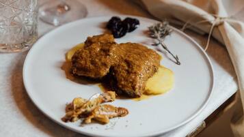 Prato com comida e um copo de vinho tinto sobre uma mesa.