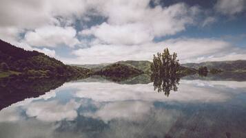 Un llac tranquil amb un reflex clar del cel i les colines circumdants.