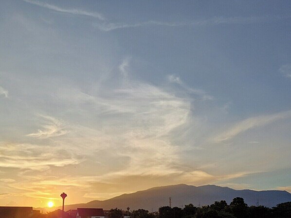 Ein Sonnenuntergang mit einem Berg im Hintergrund.