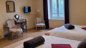 A hotel room with two beds, a desk, a chair, a TV, and a window with curtains. - Le cèdre bleu (Saint-Lattier)